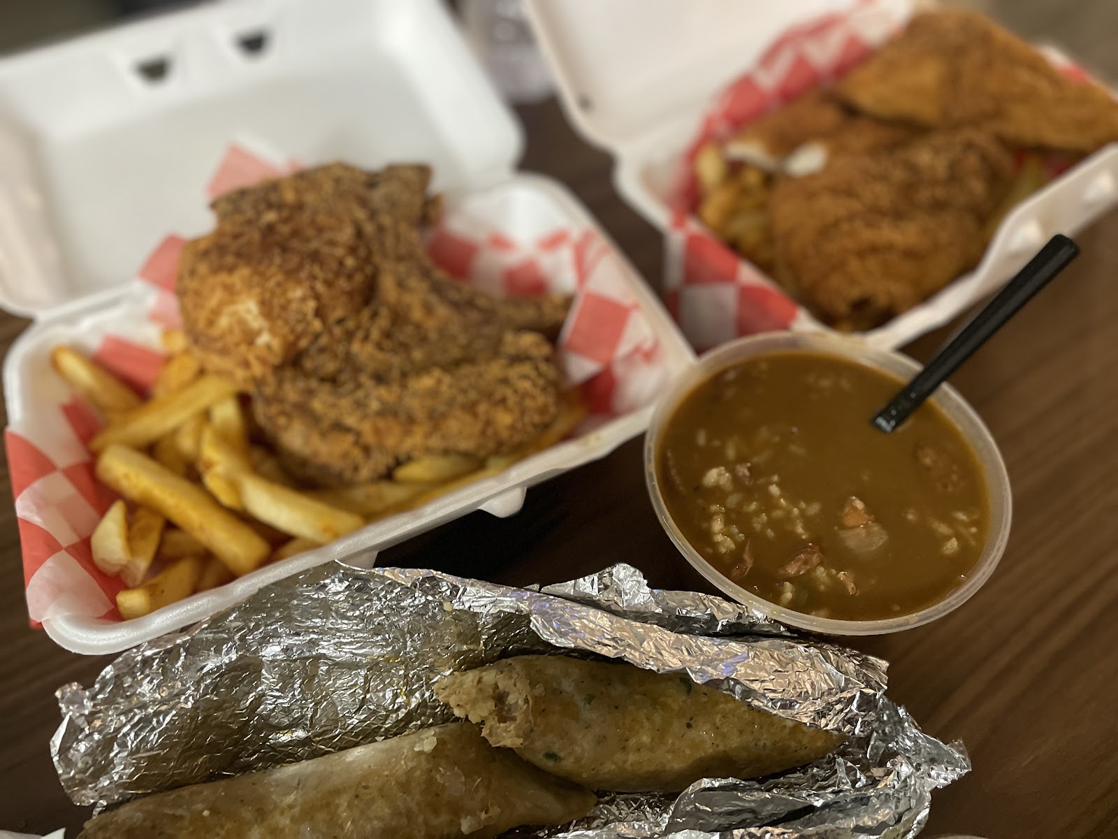 Fried pork chop plate with seasoned fries, a gumbo cup, and homemade boudin at Sauce's Southern Kitchen